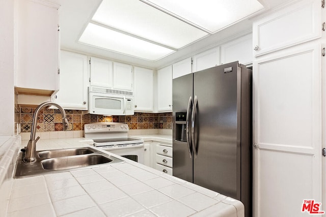 kitchen featuring backsplash, white appliances, sink, tile countertops, and white cabinets