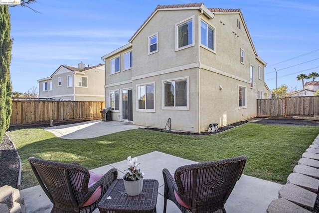 back of house featuring a lawn and a patio area