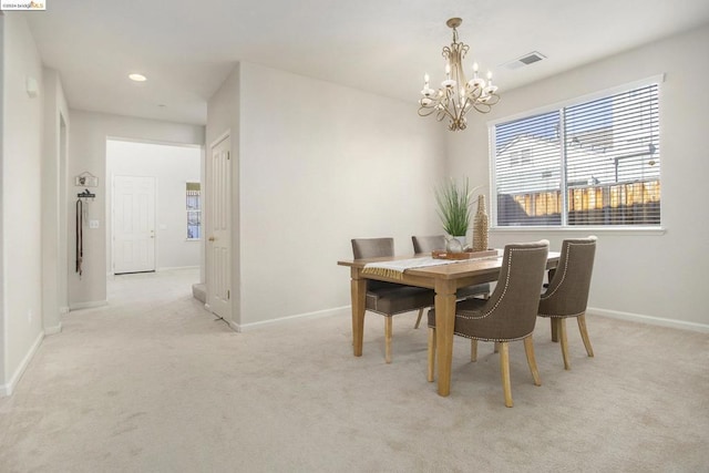 dining area featuring an inviting chandelier and light colored carpet