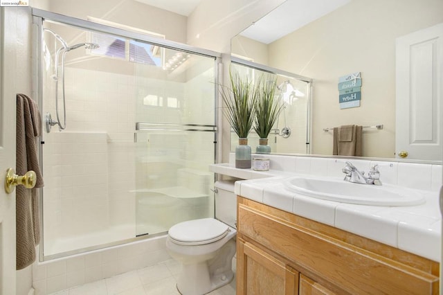 bathroom featuring tile patterned floors, vanity, toilet, and a shower with door