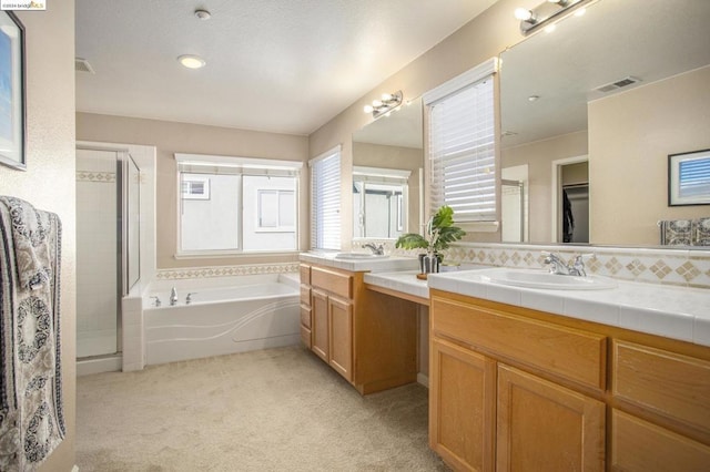 bathroom with vanity and shower with separate bathtub