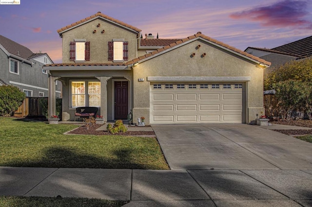 mediterranean / spanish house with a garage, a yard, and covered porch