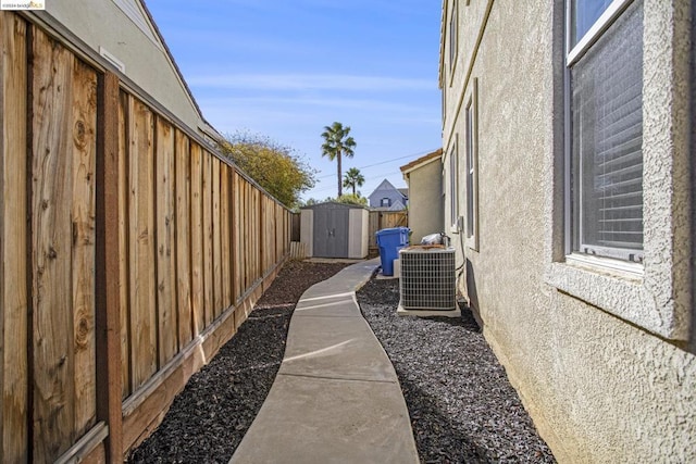 view of side of property featuring central AC unit and a storage shed