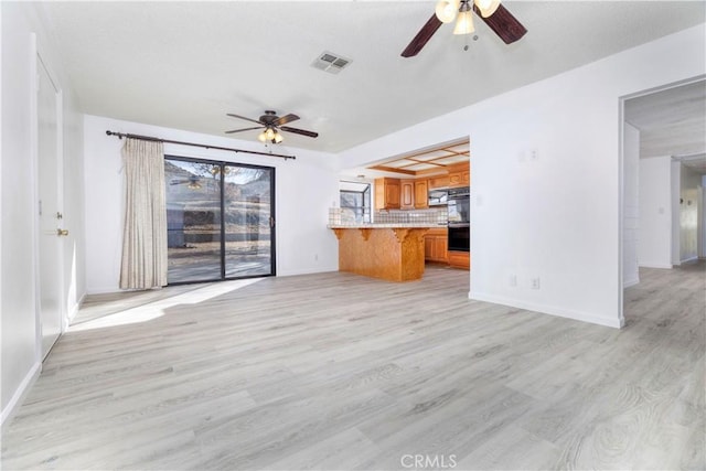 unfurnished living room with light wood-type flooring and ceiling fan