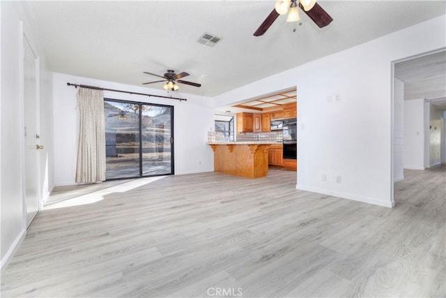 unfurnished living room featuring ceiling fan and light wood-type flooring