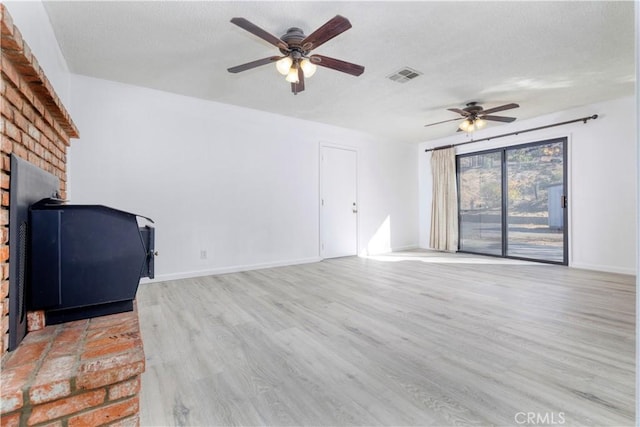 unfurnished living room featuring a textured ceiling, light hardwood / wood-style floors, and ceiling fan