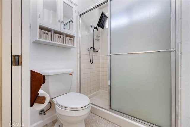 bathroom featuring tile patterned flooring, a shower with shower door, and toilet