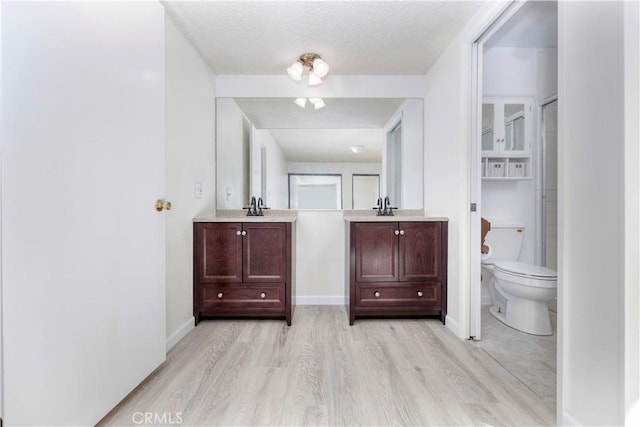 bathroom featuring toilet, vanity, a textured ceiling, and hardwood / wood-style flooring