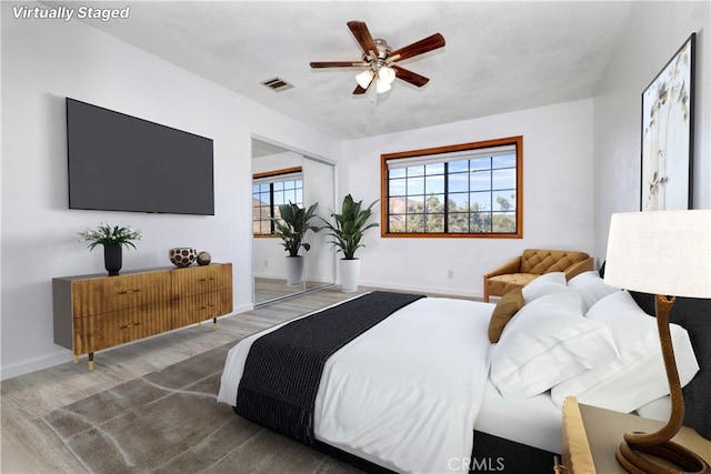 bedroom with hardwood / wood-style flooring, ceiling fan, and a textured ceiling