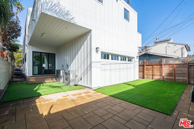 back of property with a patio area and a yard