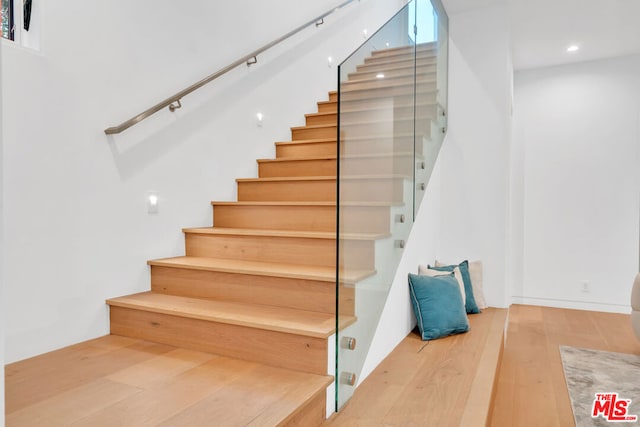 stairs featuring hardwood / wood-style floors