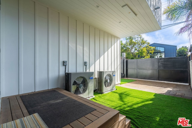 clothes washing area featuring hardwood / wood-style floors, ac unit, and a healthy amount of sunlight