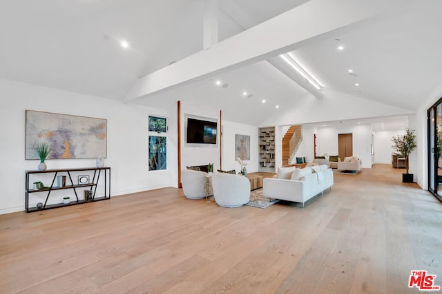 living room with a large fireplace, light hardwood / wood-style flooring, beamed ceiling, and high vaulted ceiling