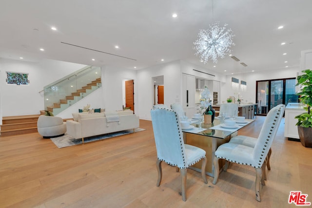 dining space with a notable chandelier and light wood-type flooring