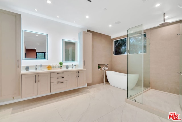 bathroom featuring vanity and independent shower and bath