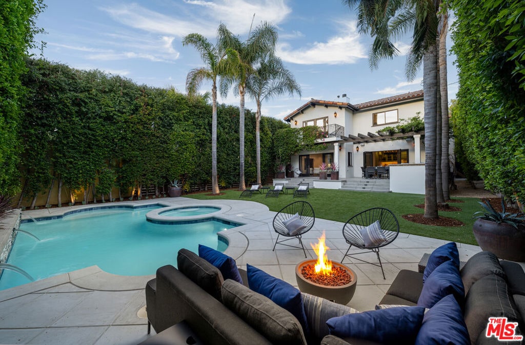 view of swimming pool featuring a lawn, a patio area, an in ground hot tub, and an outdoor living space with a fire pit