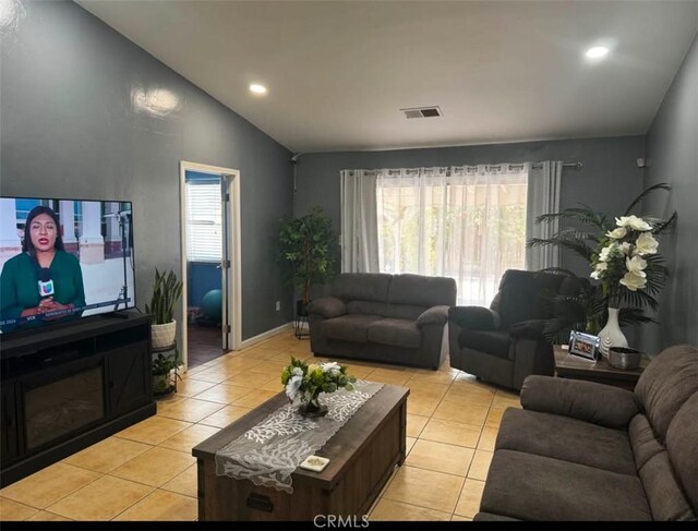 tiled living room featuring a healthy amount of sunlight and lofted ceiling