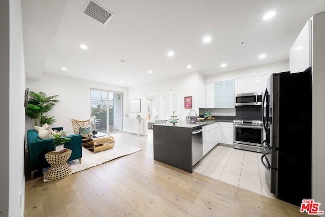 kitchen featuring white cabinets, sink, light hardwood / wood-style flooring, appliances with stainless steel finishes, and kitchen peninsula