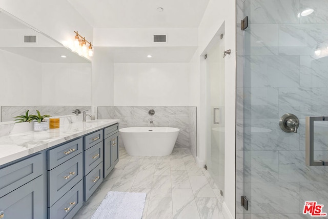 bathroom with vanity and shower with separate bathtub