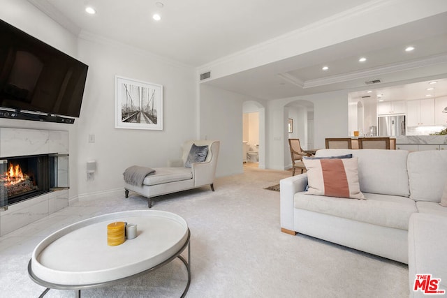 living room with crown molding and a premium fireplace