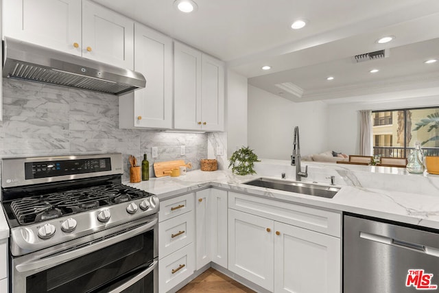 kitchen with sink, stainless steel appliances, white cabinets, and extractor fan