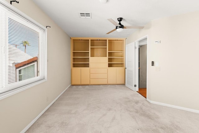 unfurnished bedroom with ceiling fan and light colored carpet