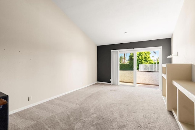 unfurnished room with light colored carpet and vaulted ceiling