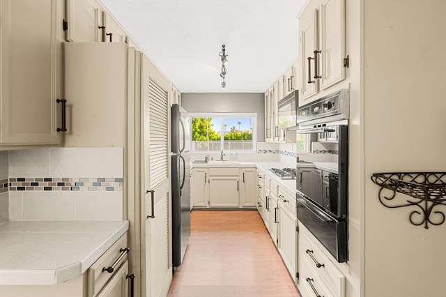 kitchen featuring tasteful backsplash, stainless steel refrigerator, and tile countertops