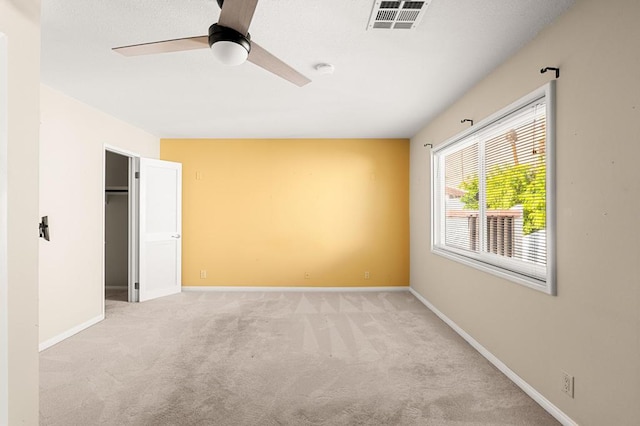 interior space with light carpet and ceiling fan