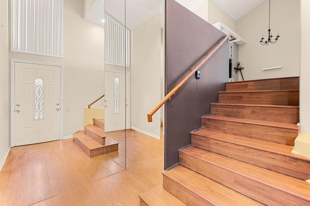 entrance foyer with hardwood / wood-style floors and a notable chandelier