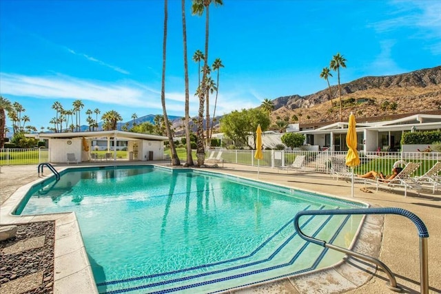 view of swimming pool featuring a patio area and a mountain view