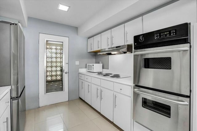 kitchen with white cabinets, stainless steel appliances, and light tile patterned floors