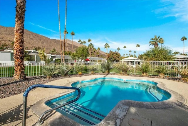 view of swimming pool with a patio area and a mountain view