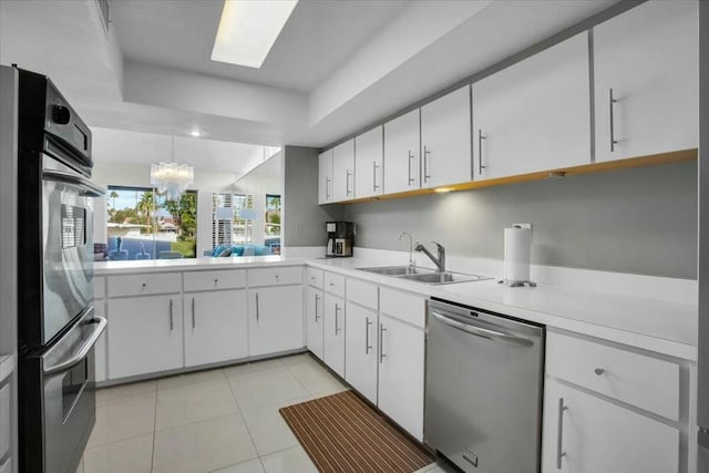 kitchen featuring white cabinets, stainless steel dishwasher, and sink