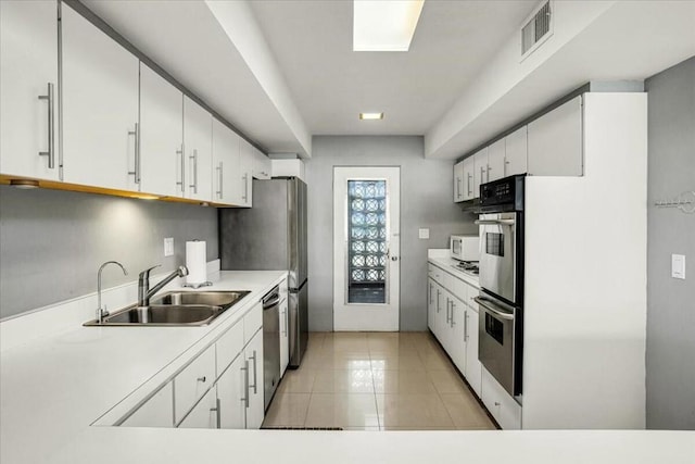 kitchen with sink, white cabinets, and appliances with stainless steel finishes