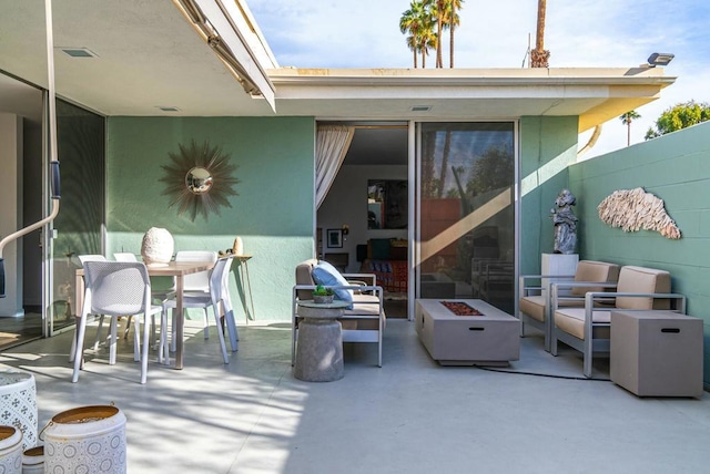 view of patio with an outdoor living space with a fire pit