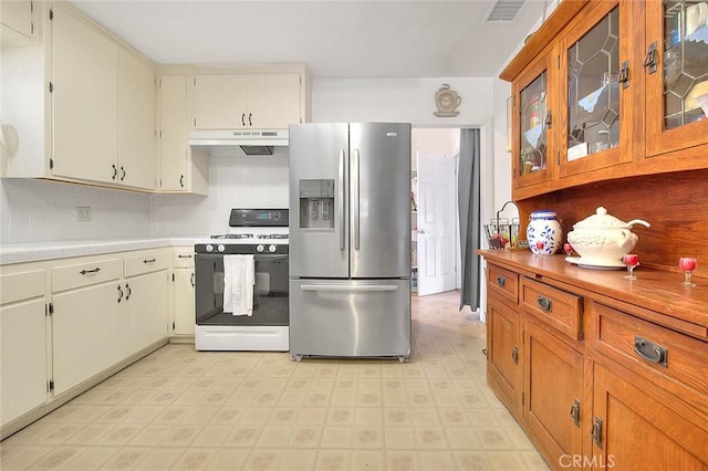 kitchen featuring white cabinetry, stainless steel fridge with ice dispenser, backsplash, and white range with gas cooktop