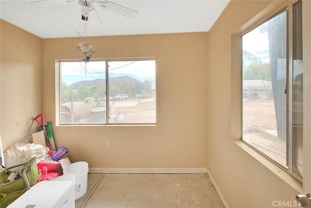 interior space featuring plenty of natural light, ceiling fan, and a mountain view