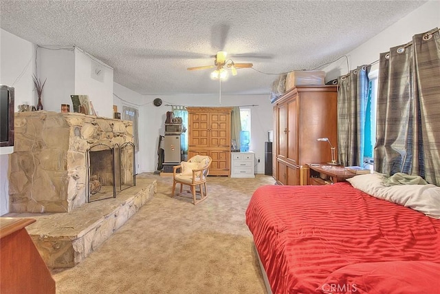 bedroom with carpet flooring, a textured ceiling, a stone fireplace, and ceiling fan