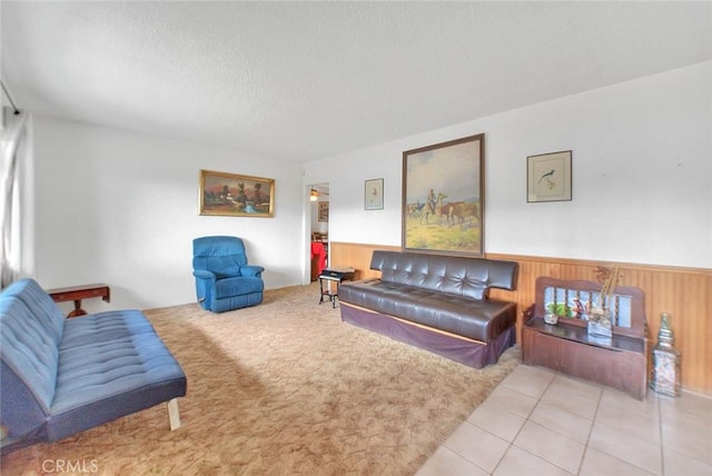 living room with wood walls, light tile patterned floors, and a textured ceiling