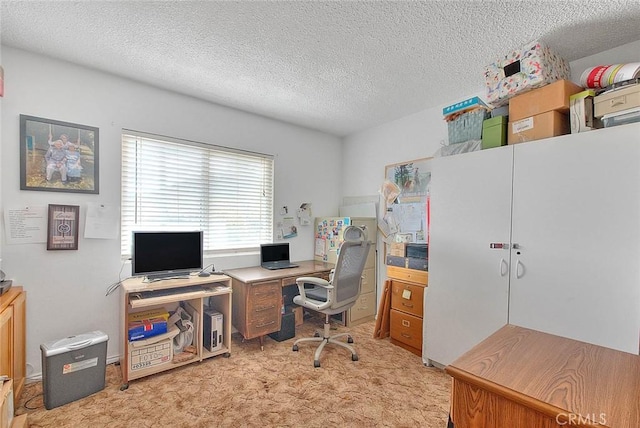 carpeted office space featuring a textured ceiling