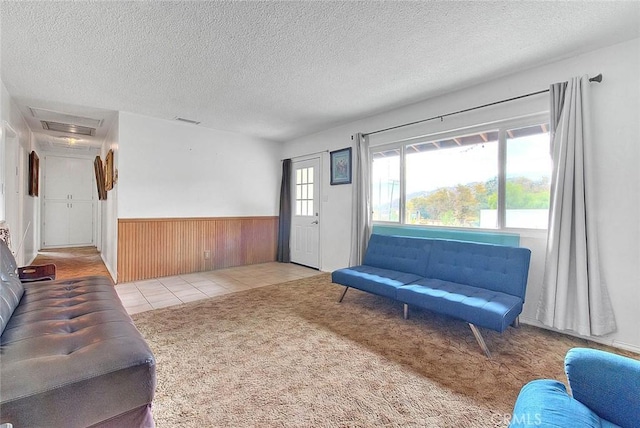 carpeted living room featuring wooden walls and a textured ceiling