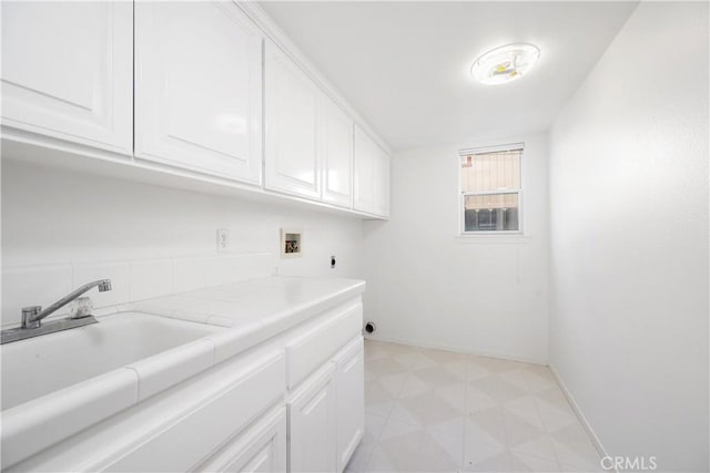 laundry room with cabinets, washer hookup, electric dryer hookup, and sink