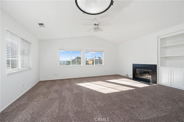 unfurnished living room featuring carpet flooring, vaulted ceiling, ceiling fan, built in features, and a fireplace