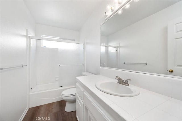 full bathroom with bathing tub / shower combination, hardwood / wood-style floors, vanity, and toilet