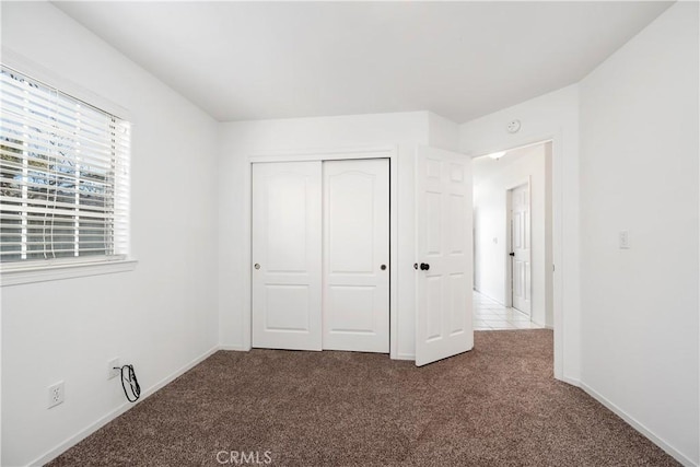 unfurnished bedroom with carpet floors and a closet