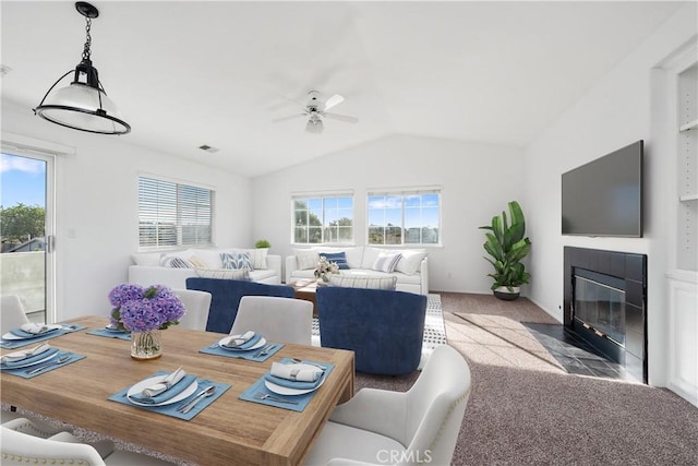 carpeted dining room featuring ceiling fan, plenty of natural light, and lofted ceiling