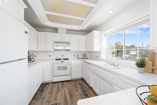 kitchen with dark hardwood / wood-style flooring, white appliances, sink, white cabinetry, and tile counters