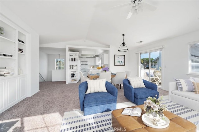 living room featuring ceiling fan, built in features, light colored carpet, and lofted ceiling