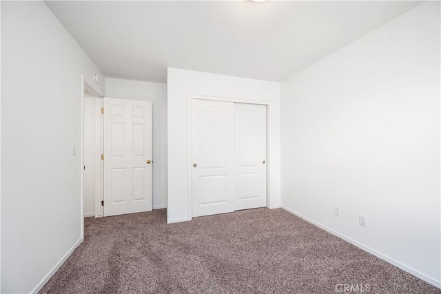 unfurnished bedroom featuring carpet flooring and a closet